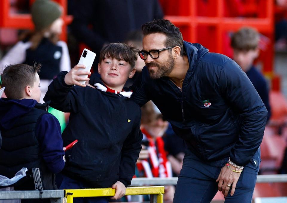 A fan takes a photo with Wrexham co-owner Ryan Reynolds before the Wrexham v Notts County match at the Racecourse Ground, Wrexham (Andrew Boyers / Action Images via Reuters)