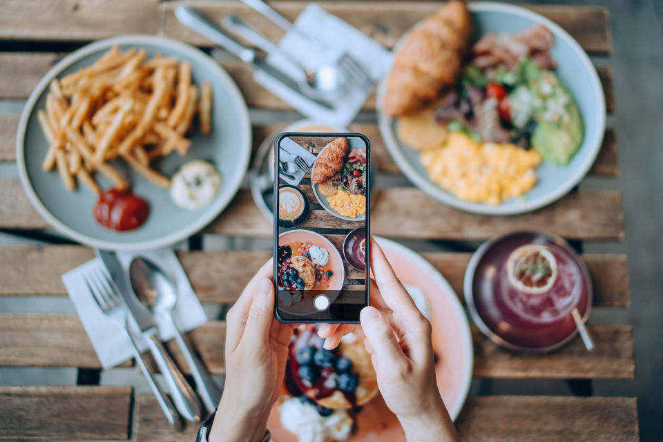 A person taking a photo of their food