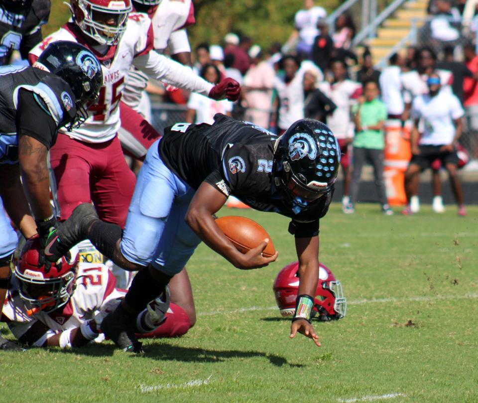 Raines safety Jayden Taylor (21) tackles Ribault quarterback T.J. Cole (2) by the ankle during the Northwest Classic. Raines and Ribault occupy the same district, along with Yulee. The FHSAA has not specified whether district runners-up qualify directly for postseason.