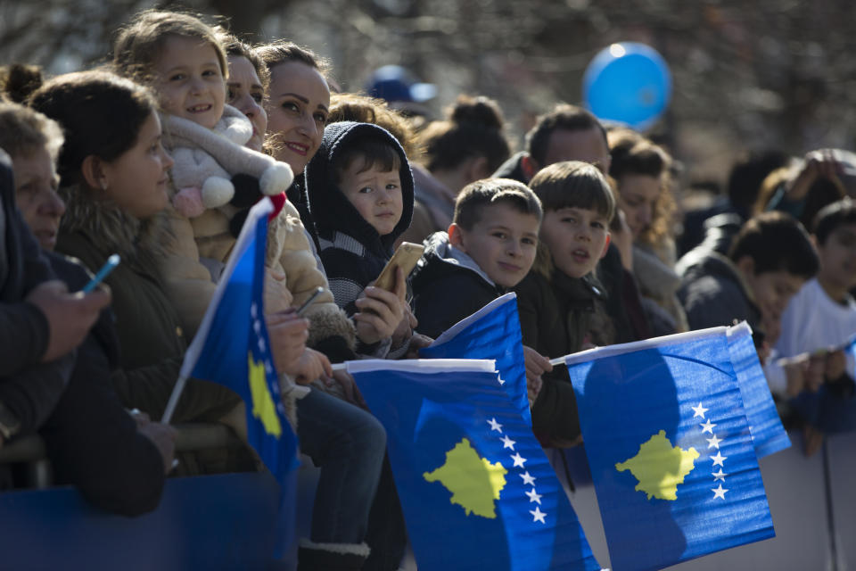 Kosovars wave national flags as they wait to watch a military parade, during celebrations to mark the 11th anniversary of independence in Pristina, Sunday, Feb. 17, 2019. Thousands of civilians filled downtown Pristina Sunday decorated with national and U.S. flags while infantry troops with light weaponry of the Kosovo Security Forces, now transformed into a regular army, paraded as a “professional, multiethnic army serving the youngest country in the world,” as President Hashim Thaci said. (AP Photo/Visar Kryeziu)