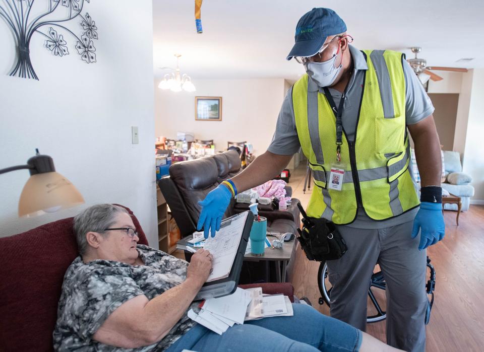 Larry Sanders with Honeywell, right, goes over paperwork with Janis Jones after completing his inspection as part of FPL's Community Energy Saver Program at her home in Milton on Thursday.