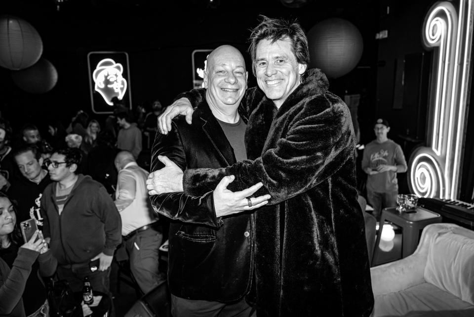 Jim Carrey wraps his arms around fellow funny man Jeff Ross in a plush coat that Ross jokes was "willed to him from Joan Rivers."