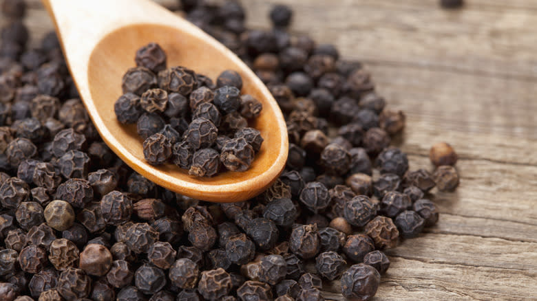 Black peppercorns in spoon