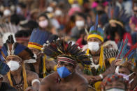 Indigenous people watch a Supreme Court session on a TV screen, that is expected to issue a ruling that will have far-reaching implications for tribal land rights, outside the Supreme Court building, in Brasilia, Brazil, Wednesday, Aug. 25, 2021. (AP Photo/Eraldo Peres)