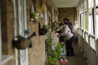 Distributors working in a pair together go door-to-door giving out home testing kits for COVID-19 from Britain's Department of Health, in Woking, England, Tuesday, Feb. 2, 2021, during England's third national lockdown since the coronavirus outbreak began. British health authorities plan to test tens of thousands of people in a handful of areas of England, including parts of Woking, in an attempt to stop a new variant of the coronavirus first identified in South Africa spreading in the community. The Department of Health says a small number of people in England who had not travelled abroad have tested positive for the strain. (AP Photo/Matt Dunham)