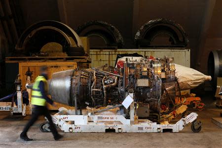 An employee walks past a dismantled engine of a Boeing 737 in a hangar of Air Salvage International (ASI) in Kemble, central England November 27, 2013. REUTERS/Stefan Wermuth