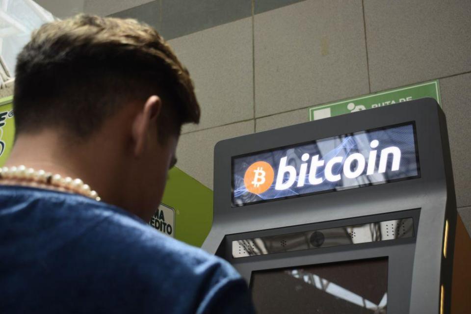 Persona frente a cajero de bitcoin.