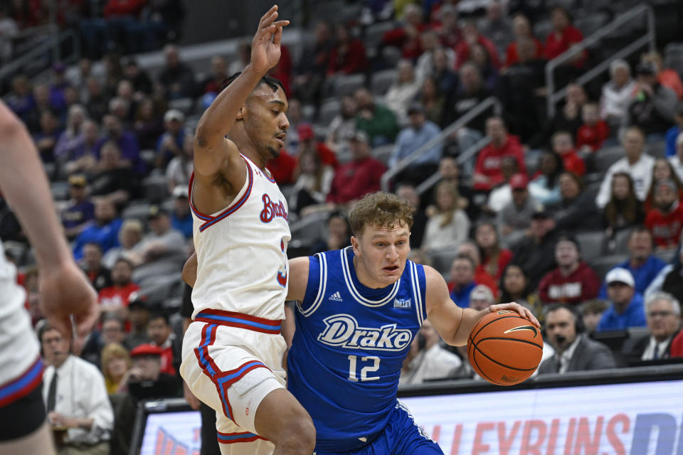 Drake guard Tucker DeVries (12) drives to the net as Bradley guard Zek Montgomery, left, defends during the first half of the championship game in the MVC basketball tournament, Sunday, March 5, 2023, in St. Louis. (AP Photo/Joe Puetz)