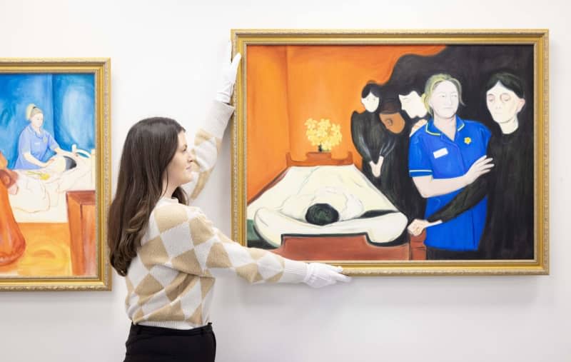 An exhibition worker hangs a reimagined version of Edvard Munch's 'By the Death Bed' by Lisa Buchanan, commissioned by end-of-life charity Marie Curie to support its flagship fundraiser, the Great Daffodil Appeal, a Mayfair Gallery at 56 Conduit Street in London. Matt Crossick/PA Wire/dpa