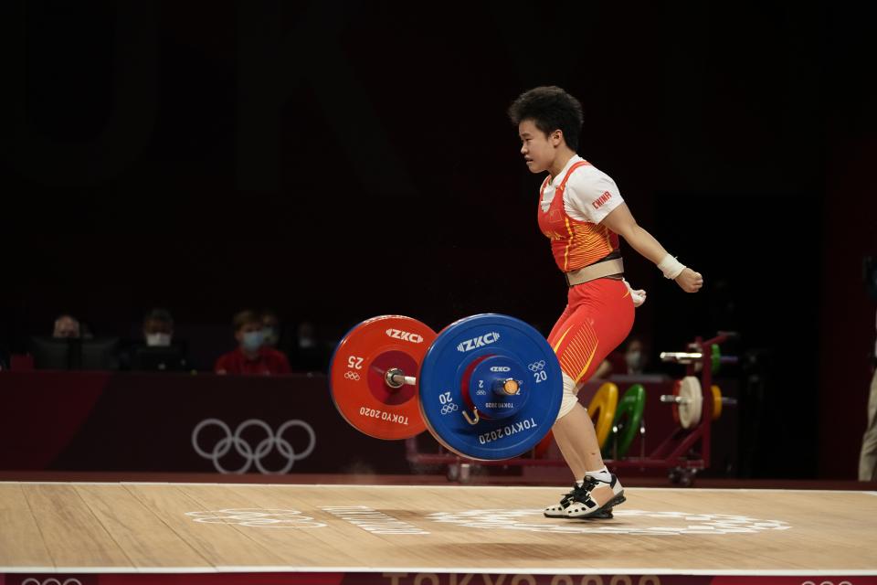 Hou Zhihui of China competes in the women's 49kg weightlifting event, at the 2020 Summer Olympics, Saturday, July 24, 2021, in Tokyo, Japan. She won the gold medal and sets Olympic record. (AP Photo/Luca Bruno)