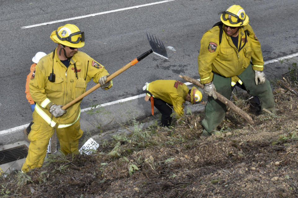 A fire prevention crew removes vegetation along California's Route 17 on Wednesday, Nov. 20, 2019, near Redwood Estates, Calif. Vehicle fires are a recurring problem in the area and authorities fear a blaze could quickly spread into nearby residential areas. (AP Photo/Matthew Brown)