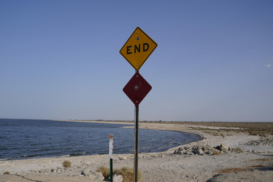 A sign is posted at the end of a road leading to the Salton Sea in Desert Shores, Calif., Wednesday, July 14, 2021. Demand for electric vehicles has shifted investments into high gear to extract lithium from geothermal wastewater around the shrinking body of water. The ultralight metal is critical to rechargeable batteries. (AP Photo/Marcio Jose Sanchez)
