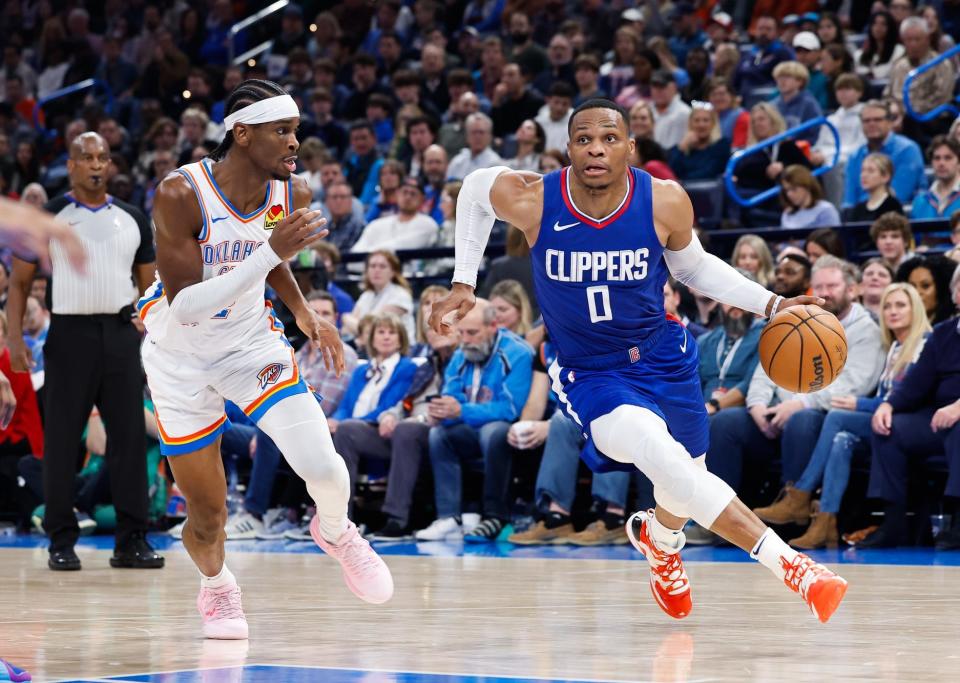 Dec 21, 2023; Oklahoma City, Oklahoma, USA; LA Clippers guard Russell Westbrook (0) drives around Oklahoma City Thunder guard Shai Gilgeous-Alexander (2) during the second half at Paycom Center. Mandatory Credit: Alonzo Adams-USA TODAY Sports