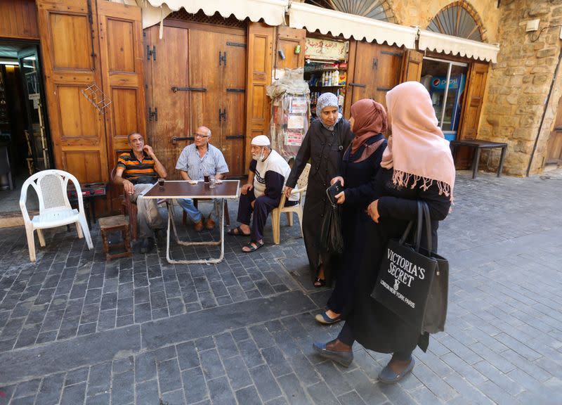 Women walk along a street in Sidon