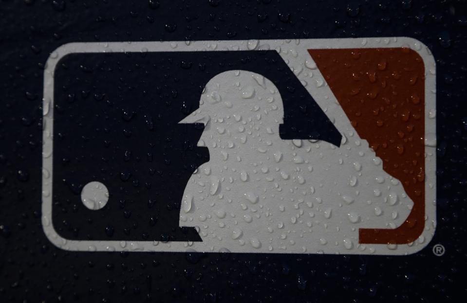 FILE - A rain-covered logo is seen at Fenway Park before Game 1 of a World Series baseball game between the Boston Red Sox and the Los Angeles Dodgers Tuesday, Oct. 23, 2018, in Boston. The clock ticked down toward the expiration of Major League Baseball’s collective bargaining agreement at 11:59 p.m. EST Wednesday night, Dec. 1, 2021, and what was likely to be a management lockout ending the sport’s labor peace at over 26 1/2 years. (AP Photo/Matt Slocum, File)