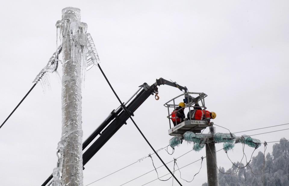Trabajadores de la compañía de energía reparan el cableado congelado en Pivka. REUTERS/Srdjan Zivulovic