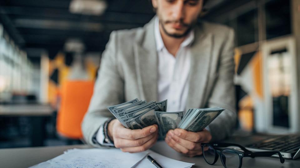 Handsome businessman working in the office and counting money.