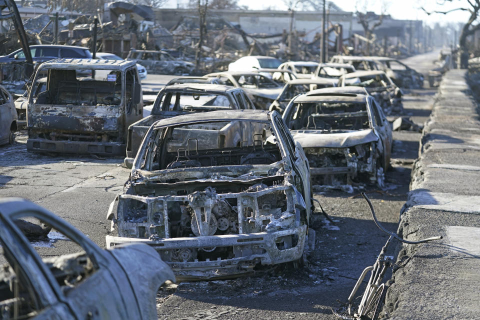 FILE - Burnt out cars line the sea walk after the wildfire on Friday, Aug. 11, 2023, in Lahaina, Hawaii. Captains of a Hawaii high school football team whose town was destroyed by a deadly wildfire are going to Super Bowl in Las Vegas as guests of the NFL. The Maui News reports the four students and three of their coaches will be serving as honorary coin toss captains before the game between the Kansas City Chiefs and the San Francisco 49ers. (AP Photo/Rick Bowmer, File)