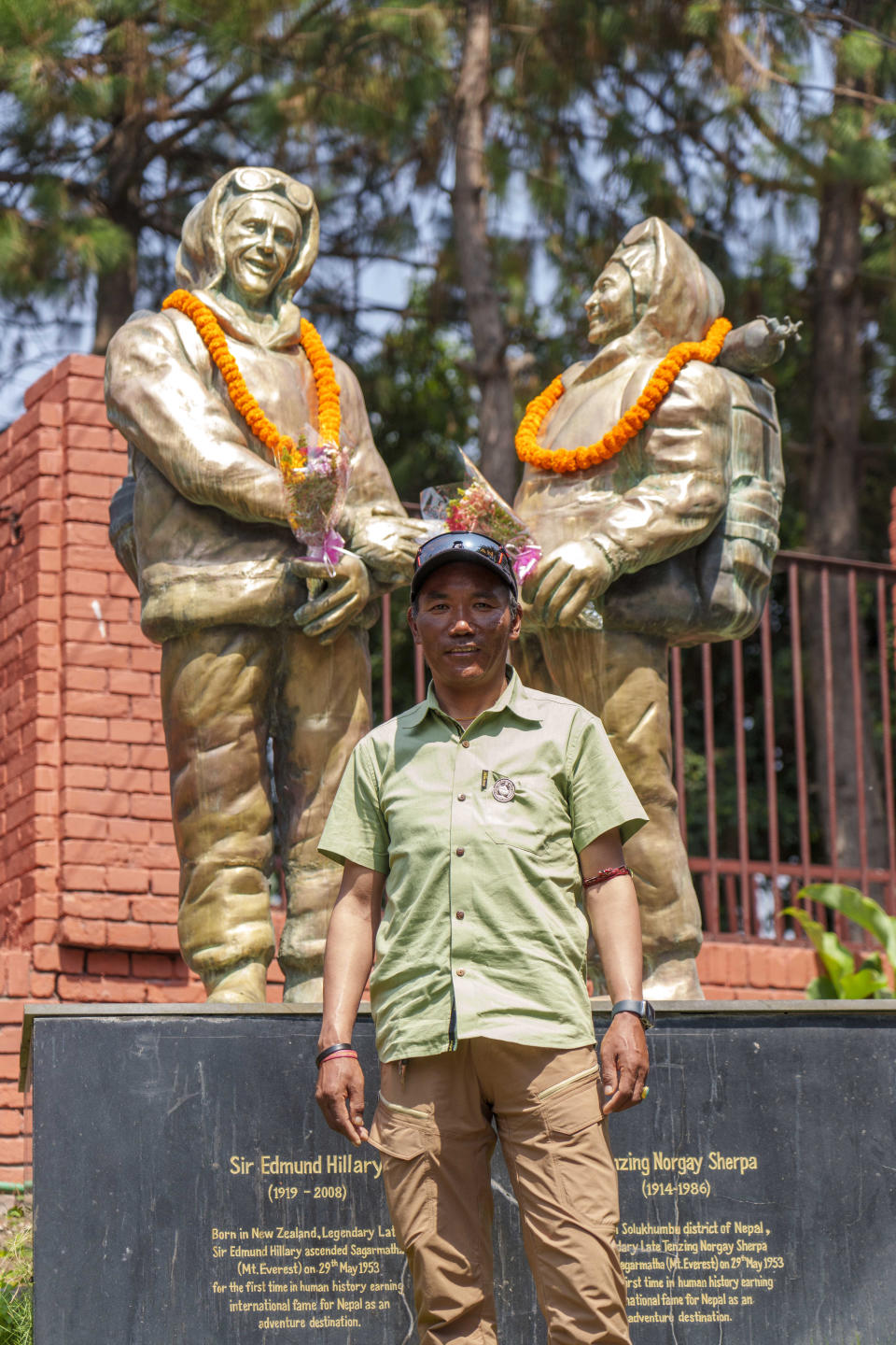 Record holder Veteran Sherpa guide Kami Rita poses for a photo in front of the statues of New Zealander Edmund Hillary, left, and his Sherpa guide Tenzing Norgay on the 70 anniversary of the first ascent of Mount Everest in Kathmandu, Nepal, Monday, May 29, 2023. The 8,849-meter (29,032-foot) mountain peak was first scaled by Hillary and Norgay on May 29, 1953. (AP Photo/Niranjan Shrestha)
