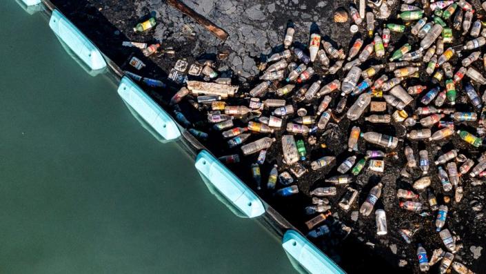 Plastic bottles pile up behind the Ocean Cleanup's Interceptor barrier in Kingston Harbour, Jamaica