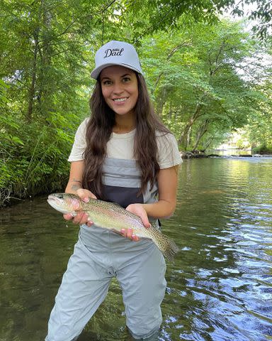 <p>Taylor Lewan Instagram</p> Taylin Lewan holding a fish while standing in a river.