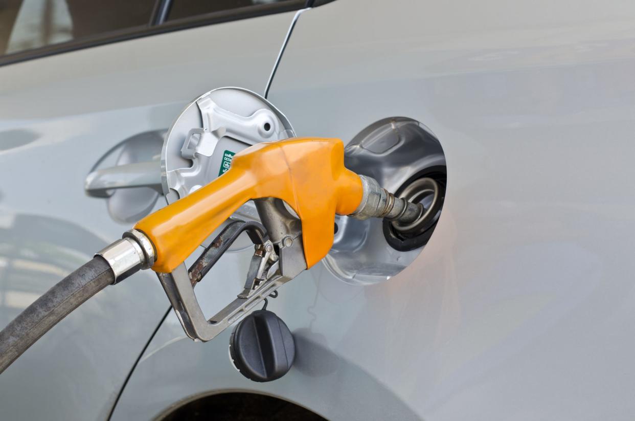 grey car at gas station being filled with fuel