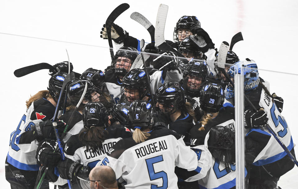 Toronto players mob teammate Sarah Nurse after she scored the winning goal against Montreal in the overtime period of a PWHL hockey game at the Bell Centre in Montreal, Saturday, April 20, 2024.(Graham Hughes/The Canadian Press via AP)