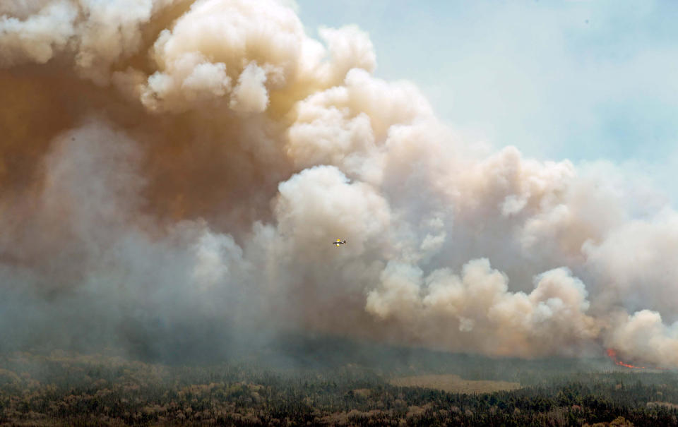 An aircraft (centre) disperses a mix of water and fire retardant over a fire near Barrington Lake in Shelburne County, N.S. in this Wednesday, May 31, 2023 handout photo. As an unprecedented string of wildfires in Nova Scotia continued to burn out of control Wednesday, thousands of residents forced to flee their homes spent a fourth day wondering what their neighbourhoods will look like when they return home.THE CANADIAN PRESS/HO-Communications Nova Scotia **MANDATORY CREDIT**