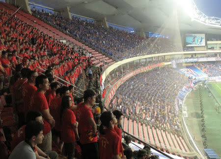 Fans watch a local soccer match between Shanghai SIPG Football Club and Shanghai Greenland Shenhua Football Club, at Hongkou Football Stadium, Shanghai, China, July 17, 2016. Picture taken July 17, 2016. REUTERS/David Stanway