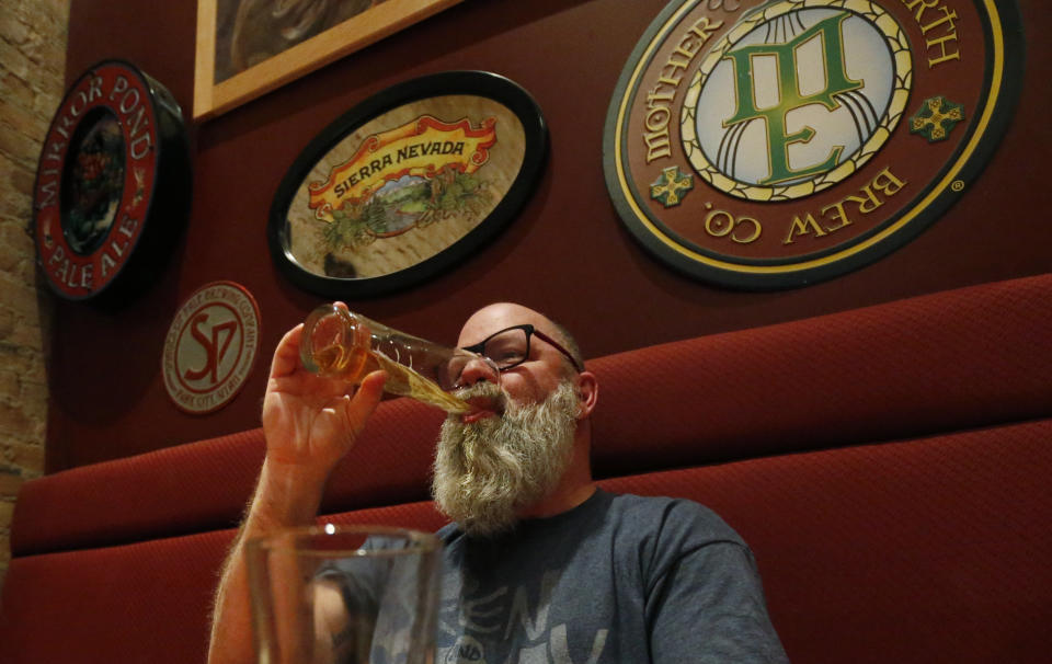 In this Dec. 20, 2018, photo, Rob Wheatley, 50, drinks a beer, at the Beer Hive Pub, in Salt Lake City. The United States' lowest DUI threshold takes effect this weekend in Utah. Lawmakers in the state approved the 0.05 percent blood-alcohol limit in 2017, and Gov. Gary Herbert signed it into law. The change goes into effect Saturday, Dec. 29, 2018. In a booth in the corner, recent Ohio transplant Wheatley said he drinks to try new craft beers, not to get drunk. He's skeptical that the law will be a serious deterrent for binge drinkers. (AP Photo/Rick Bowmer)