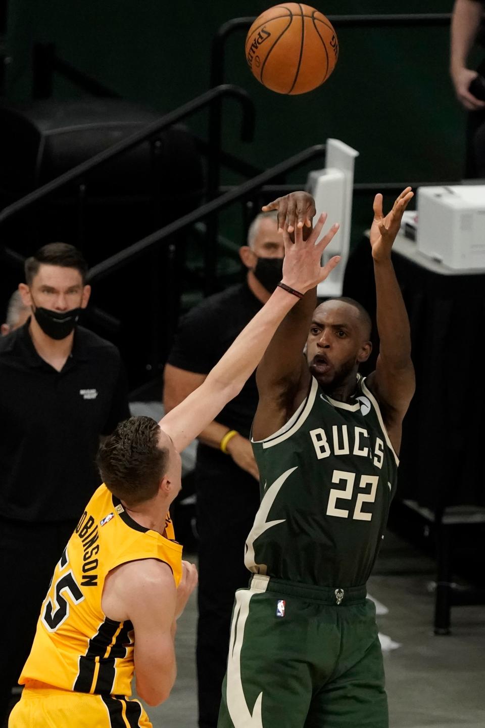Milwaukee Bucks' Khris Middleton makes a basket over Miami Heat's Duncan Robinson in the final seconds of overtime of Game 1 of their NBA basketball first-round playoff seriesSaturday, May 22, 2021, in Milwaukee. The Bucks won 109-107 to take a 1-0 lead in the series. (AP Photo/Morry Gash)