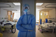 In this Sunday, Feb. 16, 2020, photo, a medical worker takes a nap at a hospital in Wuhan in central China's Hubei province. Chinese authorities on Monday reported a slight upturn in new virus cases and hundred more deaths for a total of thousands since the outbreak began two months ago. (Chinatopix via AP)