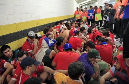 Chilean fans are surrounded by security personnel after breaking into Maracana Stadium. (AP)