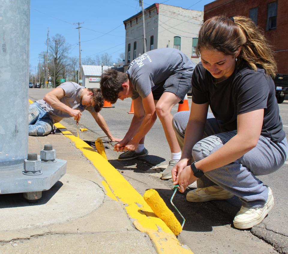 Painting curbs in downtown Quincy Monday were Sophia Snellenberger, Noah Pearson and Carter Pish. They were among 400 Quincy High School students on "Spring Fling," a community-wide service project.