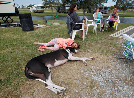 Seven year old Jordan Taylor lies with her dog at Atlanta Motor Speedway where her family was riding out Hurricane Irma in their trailer after traveling from Hollywood, Florida to Hampton, Georgia, U.S., September 10, 2017. REUTERS/Tami Chappell