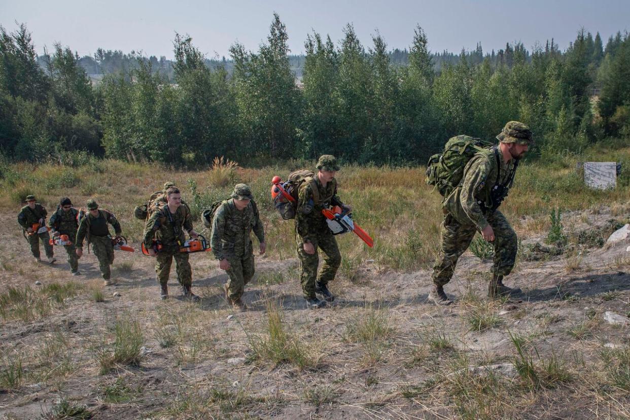 Soldiers from 2e Battalion, Royal 22e Régiment and 5 Combat Engineer Regiment head to the forest behind Parker Recreation Field to work on a fire break in Yellowknife on Aug. 16. Canadian Armed Forces personnel will be leaving the N.W.T. in the coming days.   (Master Cpl. Alana Morin, Joint Task Force North/Canadian Armed Forces - image credit)