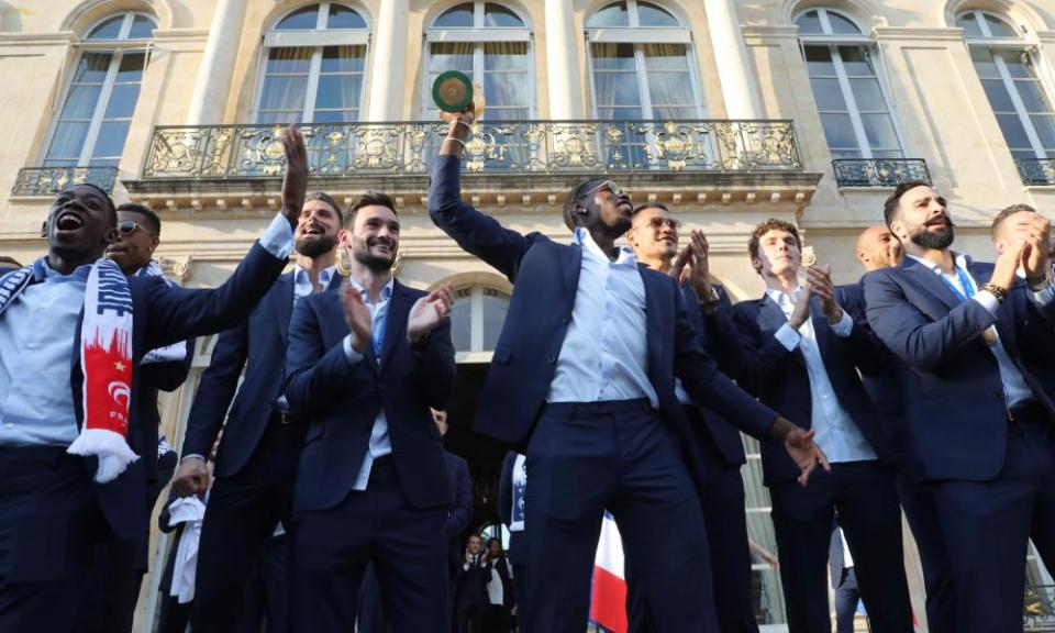 Paul Pogba holds the World Cup trophy aloft during an official reception at the Élysée Palace