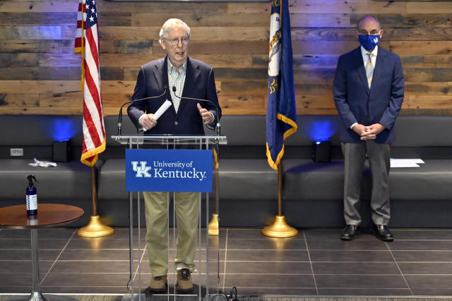 Senate Minority Leader Mitch McConnell, R-Ky., responds to a reporter's question during a news conference at a COVID-19 vaccination site in Lexington, Ky., Monday, April 5, 2021. At right is University of Kentucky President Eli Capilouto. (AP Photo/Timothy D. Easley)