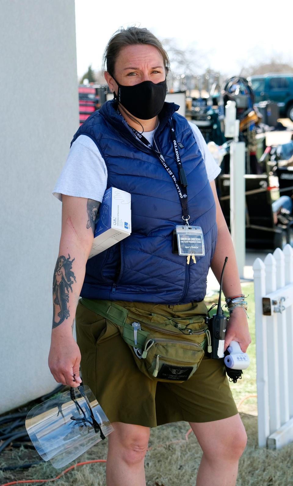 Health safety supervisor Emily O'Banion, owner of Oklahoma Set Medics, holds face shields, masks, gloves and a thermometer on the set of "American Underdog: The Kurt Warner Story."