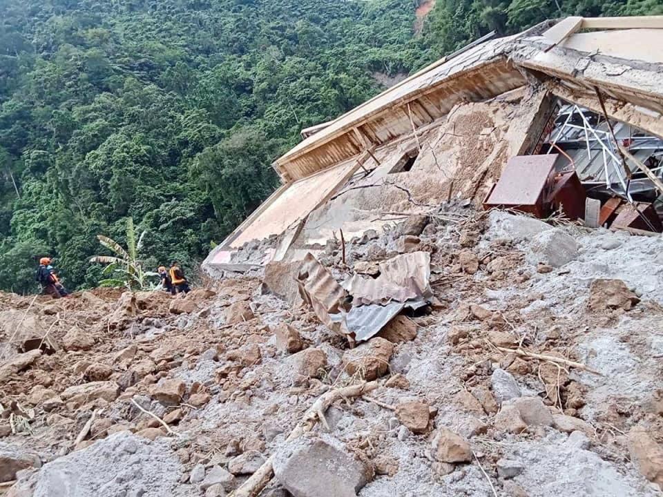 A handout photo provided by the Bureau of Fire Protection (BFP) shows rescuers working as they continue a search operation at a landslide-hit village in the town of Maco (EPA)