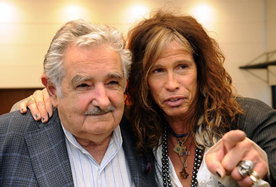 In this picture released by Uruguay's Press Office, President Jose Mujica, left, poses with Aerosmith's led singer Steven Tyler after receiving an autographed guitar as a gift at the presidential house in Montevideo, Uruguay, Tuesday, Oct. 8, 2013. The band will perform on Wednesday as part of their Latin America tour. (AP Photo/Uruguay Press Office, Alvaro Salas)