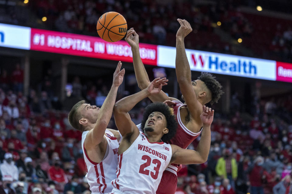 Wisconsin's Brad Davison, left, and Chucky Hepburn (23) go after a rebound against Indiana's Trayce Jackson-Davis (23) during the first half of an NCAA college basketball game Wednesday, Dec. 8, 2021, in Madison, Wis. (AP Photo/Andy Manis)