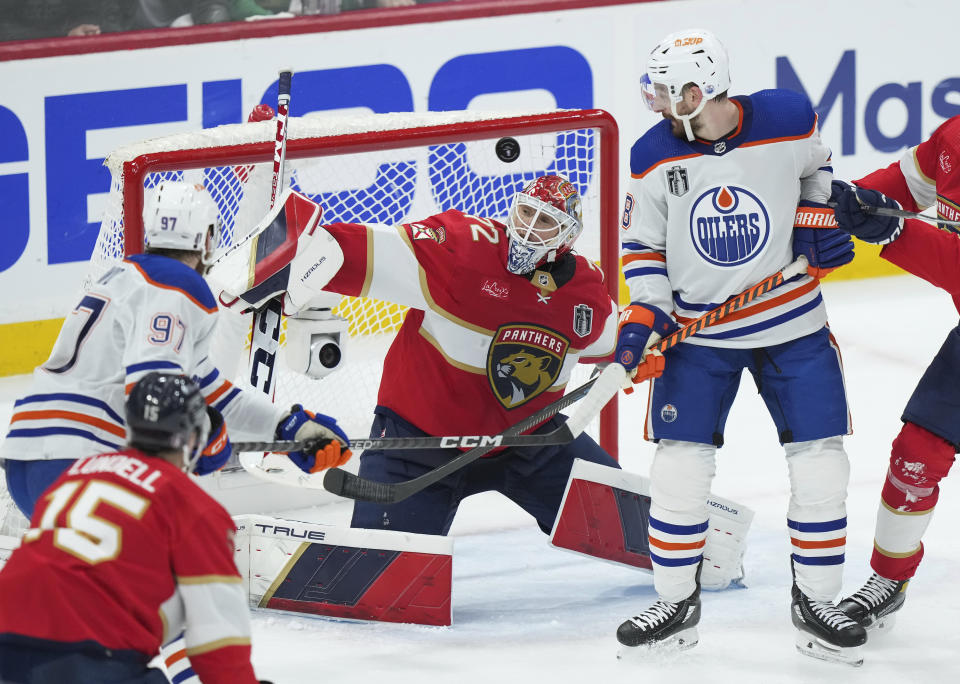 Florida Panthers goaltender Sergei Bobrovsky (72) makes a save as Edmonton Oilers forwards Zach Hyman (18) and Connor McDavid (97) watch the puck during second-period Game 2 action in the NHL hockey Stanley Cup Finals in Sunrise, Fla., Monday, June 10, 2024. (Nathan Denette/The Canadian Press via AP)