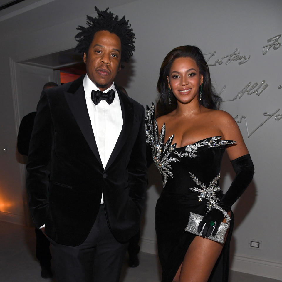 Jay-Z and Beyoncé stand next to each other at a party