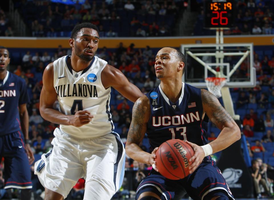 Villanova's Darrun Hilliard II (4) defends Connecticut's Shabazz Napier (13) during the second half of a third-round game in the NCAA men's college basketball tournament in Buffalo, N.Y., Saturday, March 22, 2014. (AP Photo/Bill Wippert)