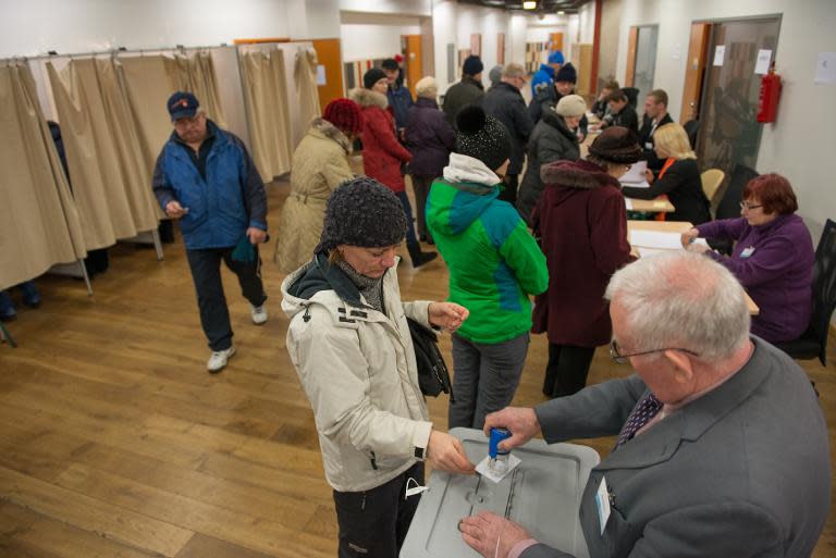 Voters are seen at a polling station during a parliamentary election in Tallinn on March 1, 2015