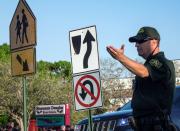 <p>Un policía hace guardia mientras padres y estudiantes llegan a la escuela Marjory Stoneman Douglas en Parkland, estado de Florida (Estados Unidos), hoy 28 de febrero de 2018. Dos semanas después de que un exalumno matara a 17 personas, las aulas de la escuela vuelven a llenarse de estudiantes, muchos de ellos convertidos en activistas contra las armas. EFE/ Cristobal Herrera </p>