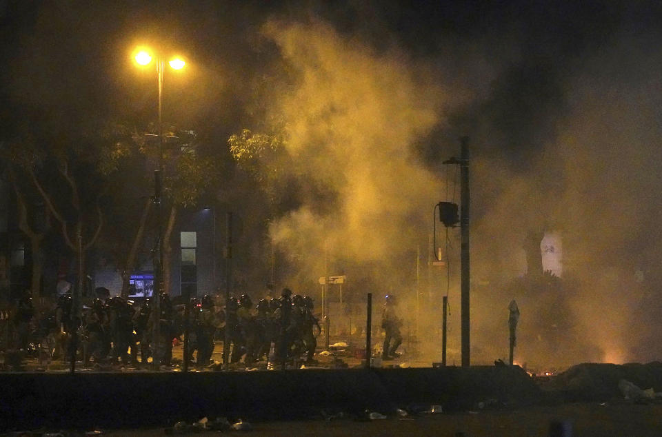 Police in riot gear move into the campus of Hong Kong Polytechnic University in Hong Kong, early Monday, Nov. 18, 2019. Hong Kong police have stormed into a university campus held by protesters after an all-night standoff. Fiery explosions could be seen inside as riot officers entered before dawn Monday. (AP Photo/Vincent Yu)