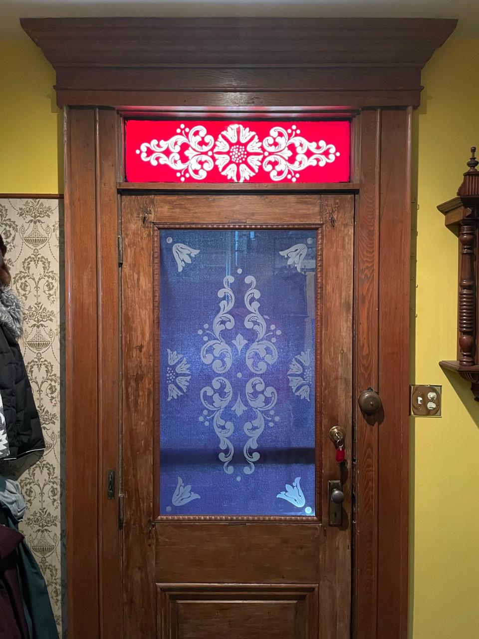 The Miller front door is restored with a new sheet of glass, which includes etchings that pick up design elements of the transom, which is original to the house.