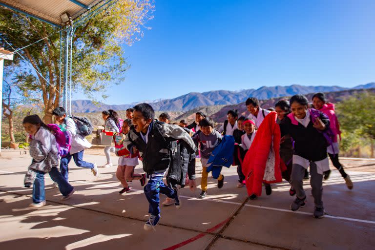 Tras saludar a la bandera los niños están listos para volver a las casas entre los cerros.